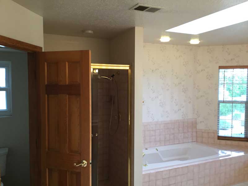 A bathroom with a bathtub and a shower
Description automatically generated