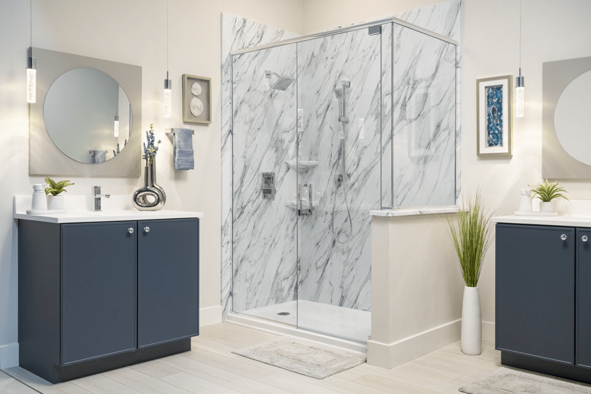 A clean, modern bathroom with navy blue cabinets, silver furnishings, and a glass shower. | Re-Bath